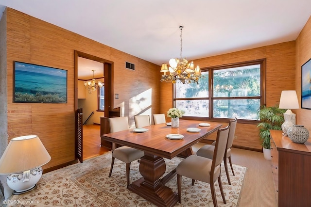 dining area with an inviting chandelier and light hardwood / wood-style floors