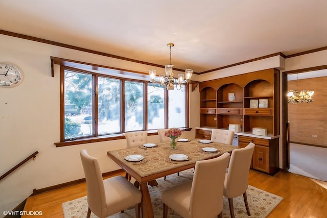 dining room featuring ornamental molding, a chandelier, and light hardwood / wood-style floors