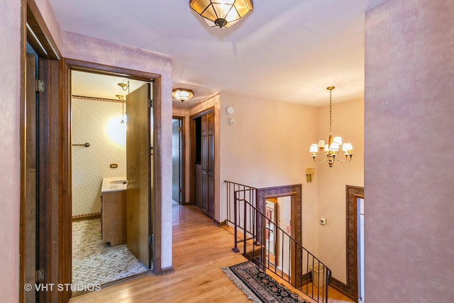 hall featuring a chandelier and light hardwood / wood-style flooring