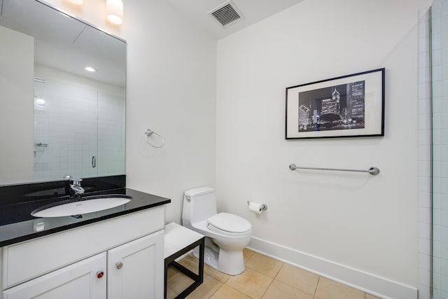 bathroom with vanity, a shower with shower door, toilet, and tile patterned flooring