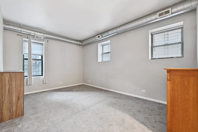 carpeted spare room featuring a wealth of natural light