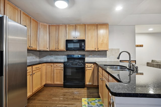 kitchen with sink, kitchen peninsula, black appliances, dark hardwood / wood-style floors, and dark stone counters