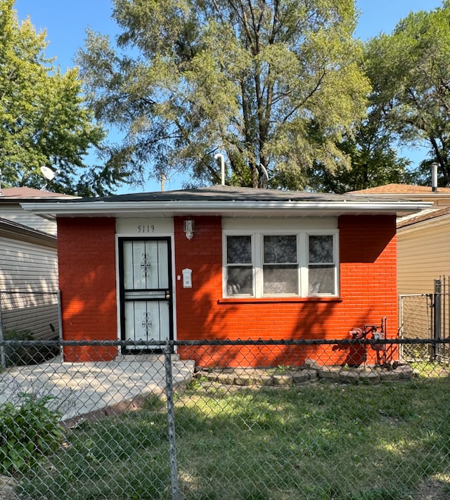 view of front of home featuring brick siding, fence, and a front yard