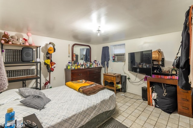bedroom featuring light tile patterned flooring, baseboards, and cooling unit
