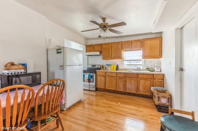 kitchen with gas range, under cabinet range hood, freestanding refrigerator, a ceiling fan, and black microwave