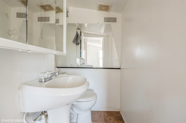 bathroom featuring a shower, toilet, and tile patterned floors