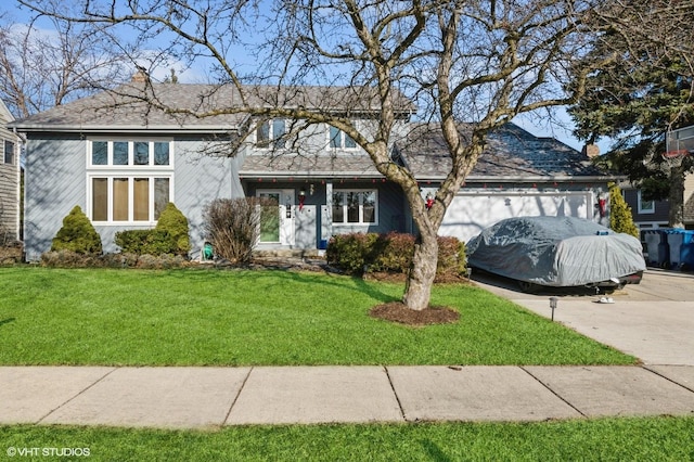 view of front of property with a front yard and a garage