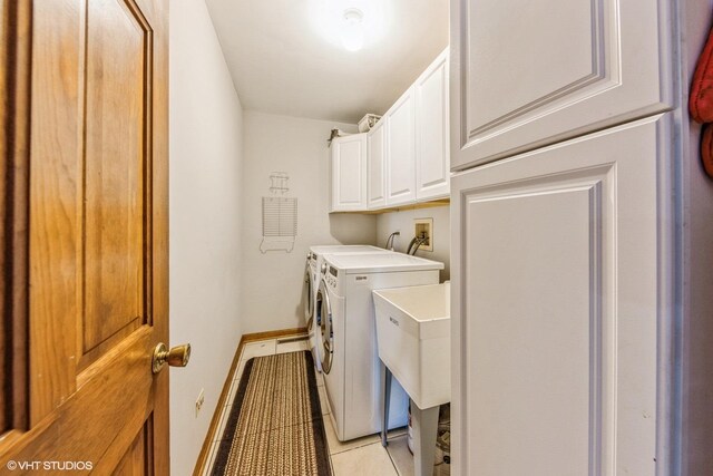 clothes washing area featuring cabinets, separate washer and dryer, and light tile patterned floors