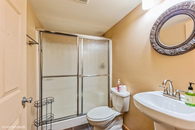 bathroom featuring sink, tile patterned floors, toilet, and an enclosed shower