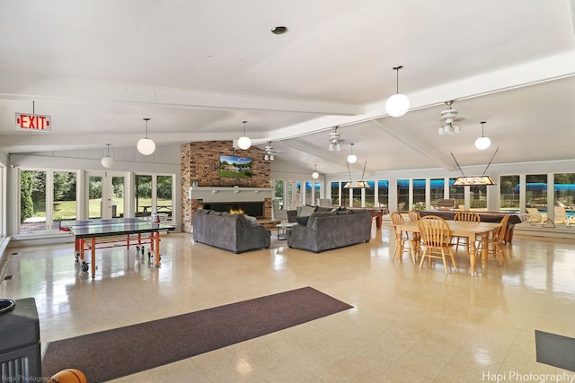 living room featuring vaulted ceiling with beams and a large fireplace