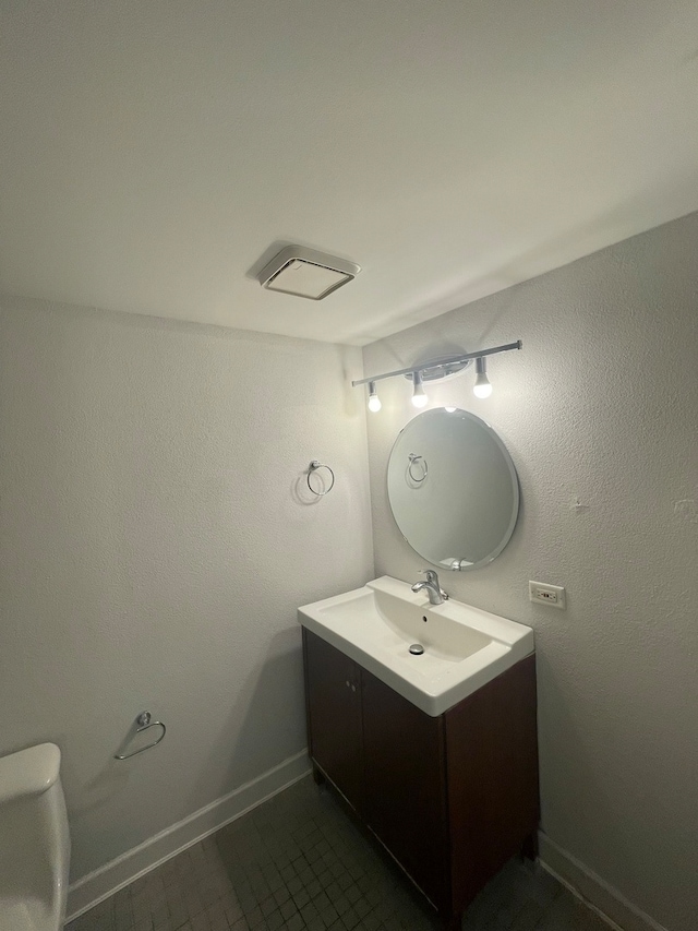 bathroom featuring tile patterned flooring, vanity, and toilet