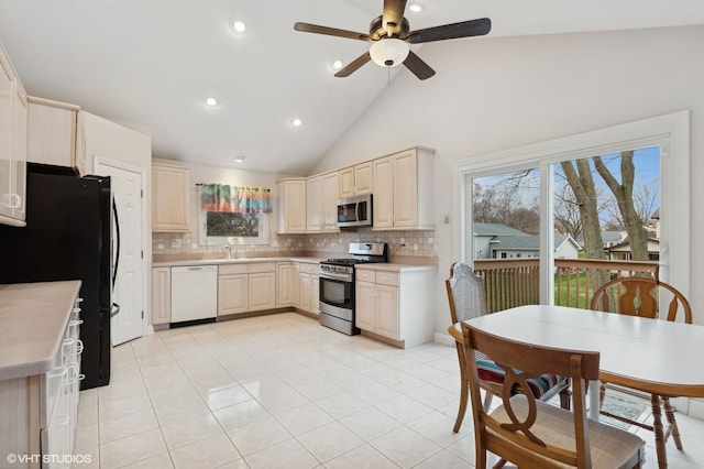 kitchen with decorative backsplash, stainless steel appliances, sink, high vaulted ceiling, and light tile patterned flooring