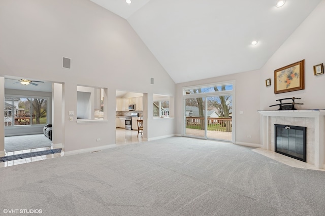 unfurnished living room with light colored carpet, high vaulted ceiling, and a wealth of natural light