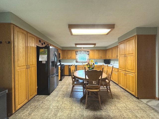 kitchen featuring black range, stainless steel fridge, and sink