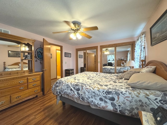 bedroom with a textured ceiling, dark hardwood / wood-style flooring, and ceiling fan