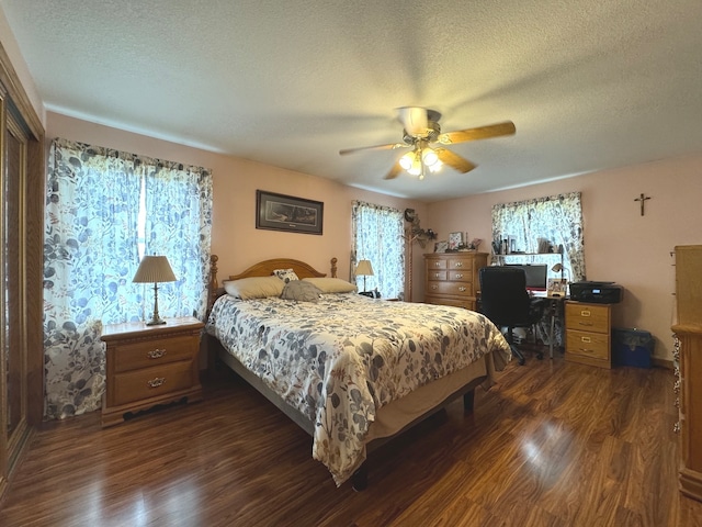 bedroom with a textured ceiling, dark hardwood / wood-style flooring, and ceiling fan