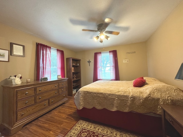 bedroom with ceiling fan and dark wood-type flooring