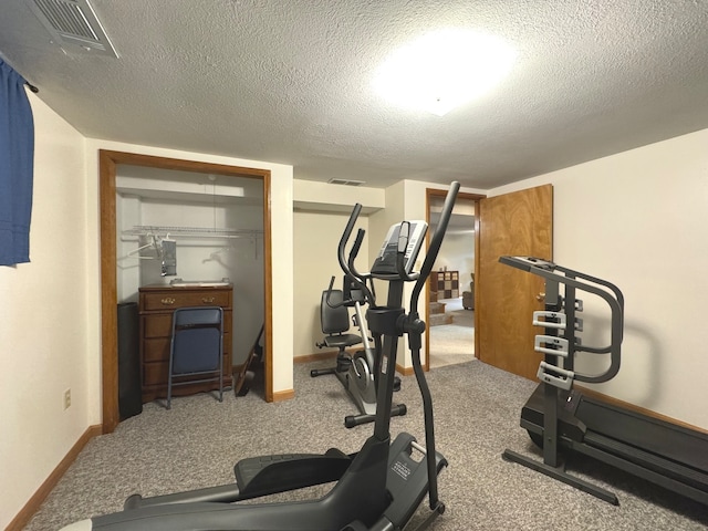 workout area featuring carpet and a textured ceiling