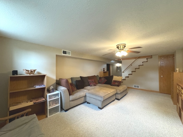 carpeted living room featuring a textured ceiling and ceiling fan