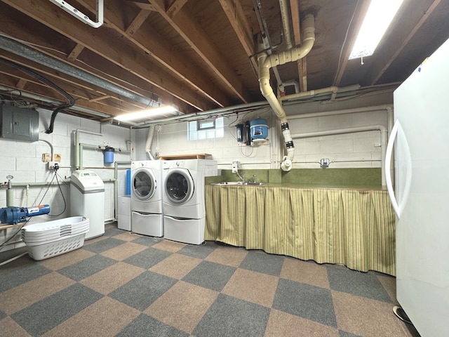 laundry room featuring electric panel, washer and clothes dryer, and sink