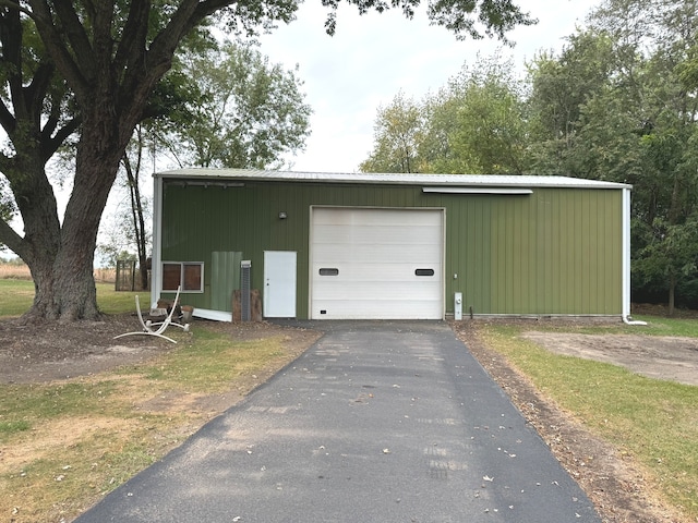 garage featuring wood walls and a yard