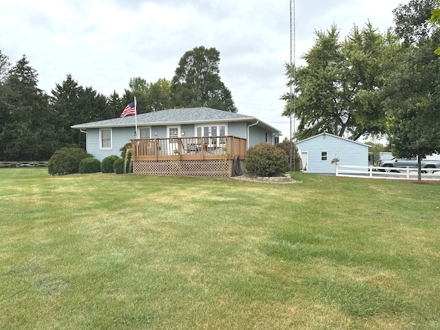 rear view of house with a wooden deck and a yard