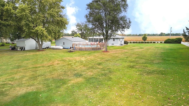 view of yard with a storage shed, a swimming pool, and a rural view