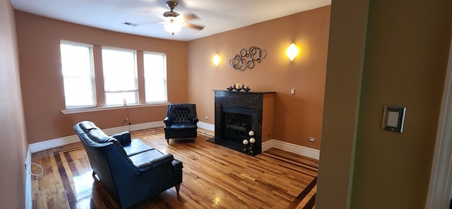 living area featuring hardwood / wood-style floors and ceiling fan