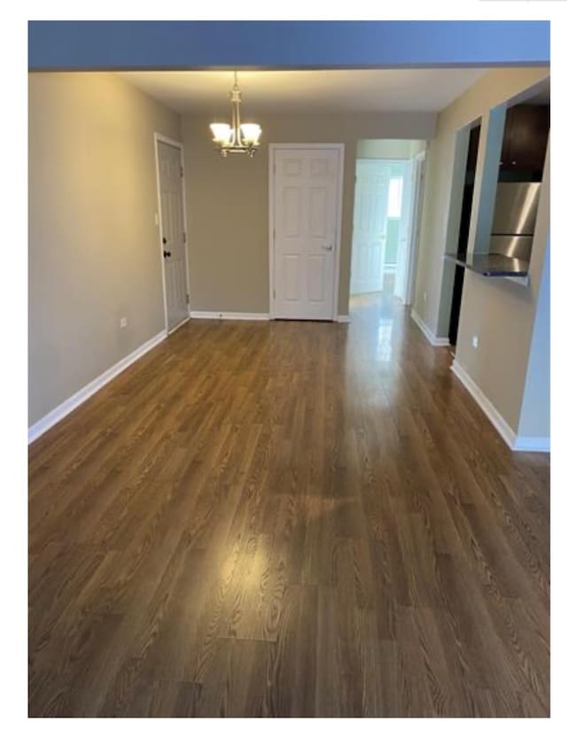 interior space with a notable chandelier and dark wood-type flooring