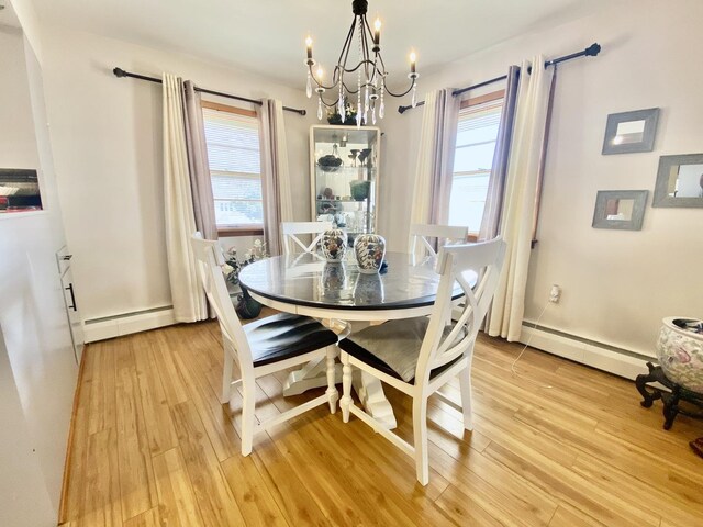 dining room with hardwood / wood-style floors, a baseboard heating unit, and a notable chandelier