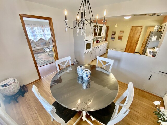 dining area with an inviting chandelier and dark wood-type flooring