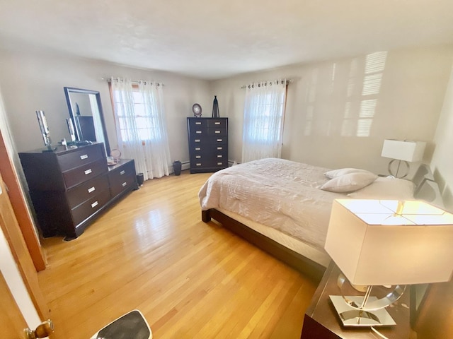 bedroom featuring a baseboard radiator and light hardwood / wood-style floors