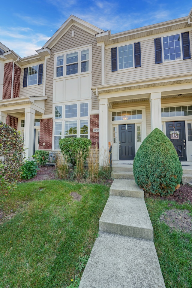 multi unit property with a front lawn and covered porch