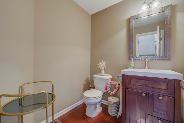 bathroom with hardwood / wood-style floors, vanity, toilet, and vaulted ceiling