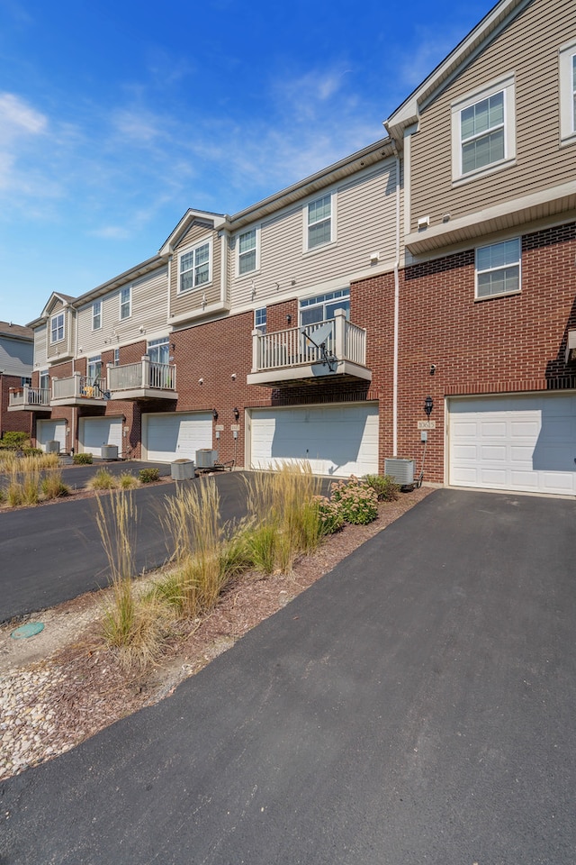 exterior space with a balcony, a garage, and central air condition unit