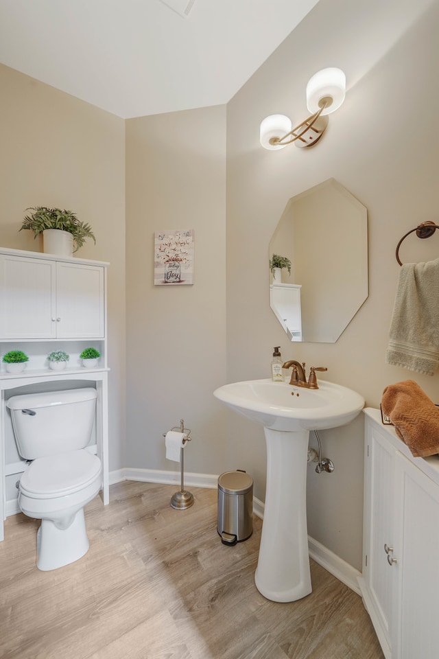 bathroom with wood-type flooring and toilet