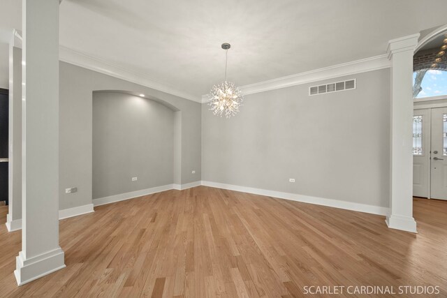 empty room featuring crown molding, a healthy amount of sunlight, light hardwood / wood-style flooring, and french doors