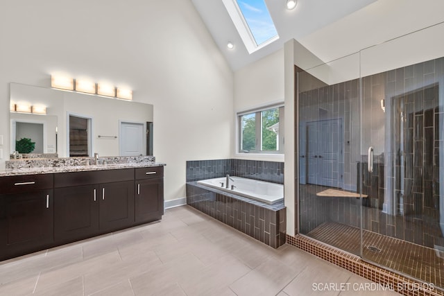 bathroom featuring tile patterned floors, separate shower and tub, a skylight, high vaulted ceiling, and vanity