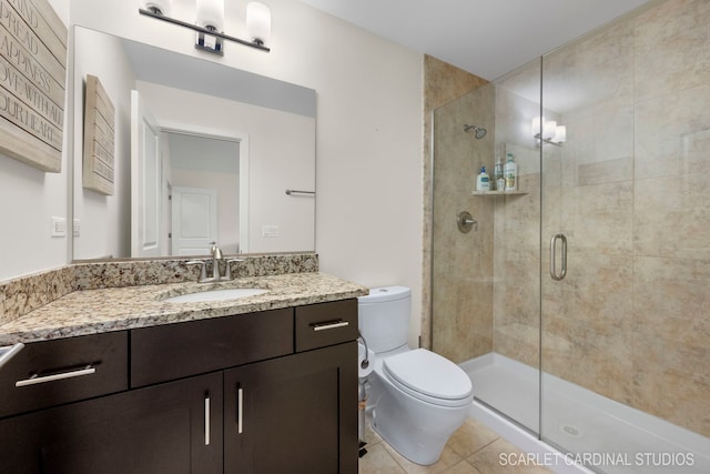 bathroom featuring a shower with door, vanity, tile patterned flooring, and toilet