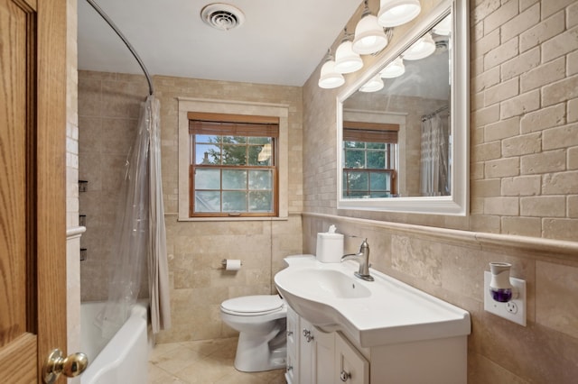 full bathroom featuring tile walls, shower / bathtub combination with curtain, vanity, tile patterned flooring, and toilet