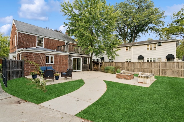 back of property featuring a fire pit, a lawn, and a patio area