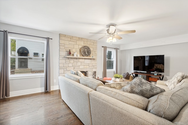 living room with a healthy amount of sunlight, a stone fireplace, hardwood / wood-style floors, and ceiling fan