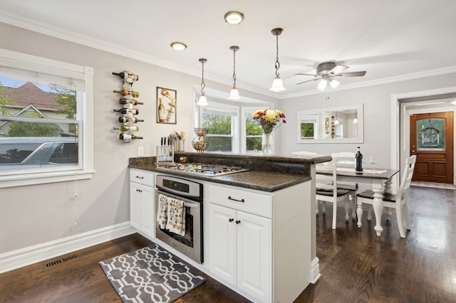 kitchen featuring white cabinets, kitchen peninsula, dark hardwood / wood-style flooring, stainless steel appliances, and ceiling fan