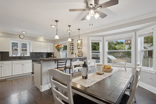 dining space featuring ornamental molding, ceiling fan, sink, and dark hardwood / wood-style flooring