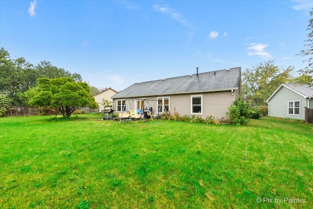 back of house with a lawn