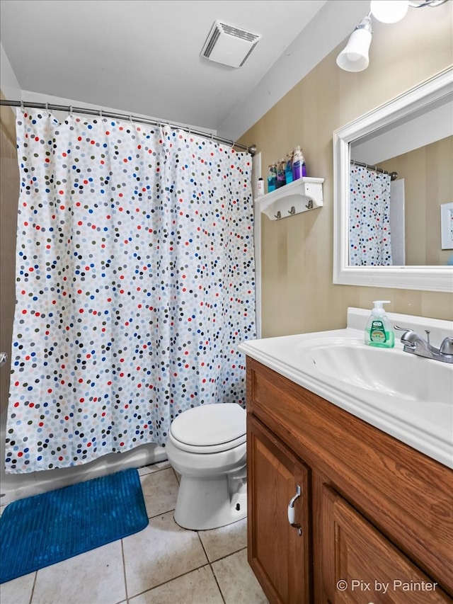 bathroom featuring tile patterned flooring, curtained shower, vanity, and toilet