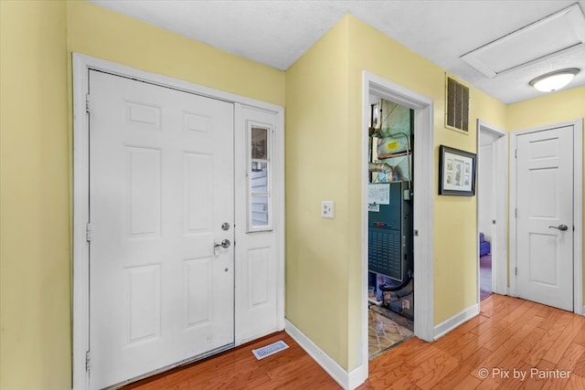 entryway featuring a textured ceiling and light hardwood / wood-style flooring