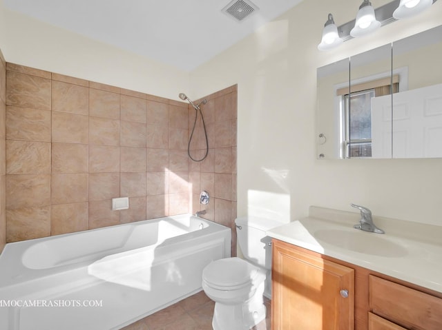 full bathroom with tiled shower / bath combo, toilet, tile patterned floors, and vanity