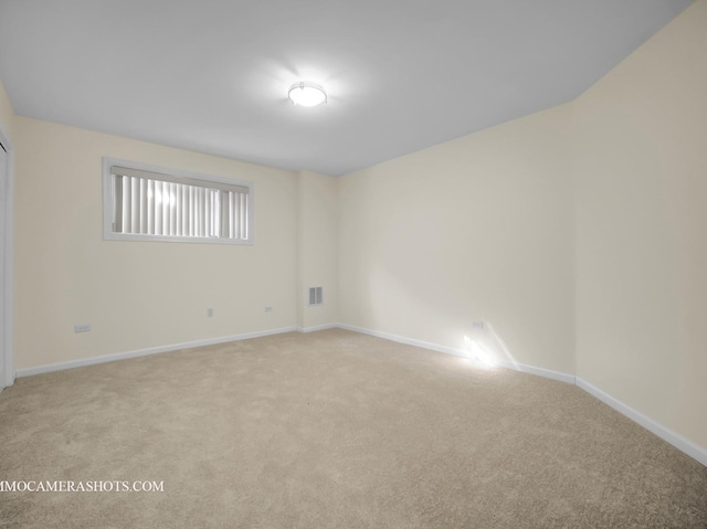 unfurnished room featuring light colored carpet