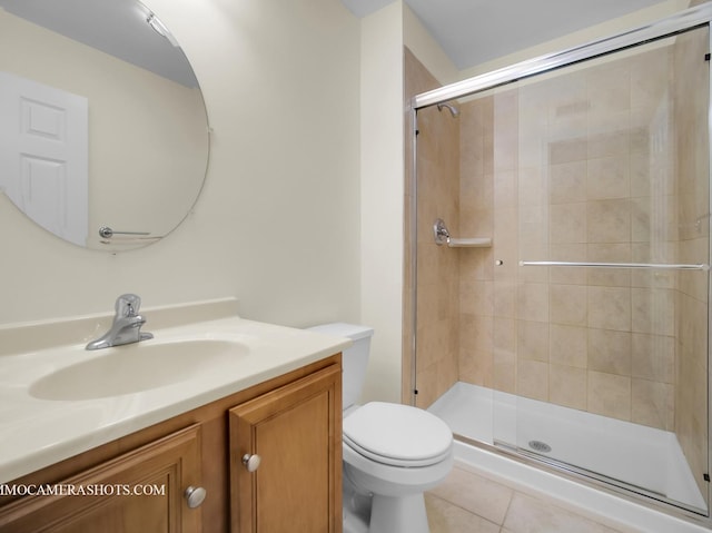 bathroom featuring toilet, tile patterned floors, vanity, and walk in shower